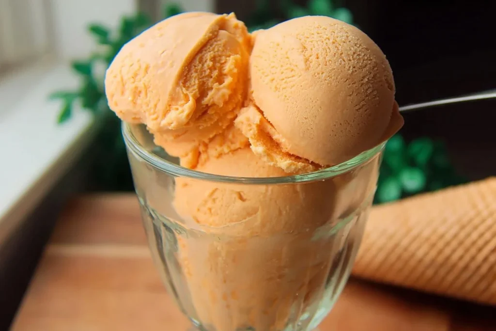 A bowl of sweet potato pie ice cream topped with whipped cream and cinnamon
