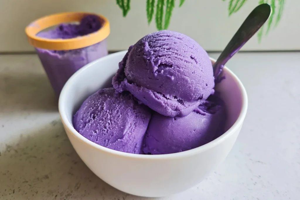 A bowl of creamy ube ice cream topped with sprinkles and vibrant purple hues.