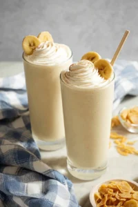 Delicious homemade banana milkshake in a glass with a ripe banana