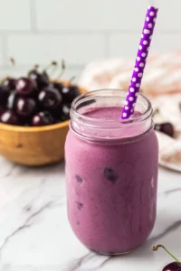 Delicious cherry vanilla milkshake topped with whipped cream and a cherry.