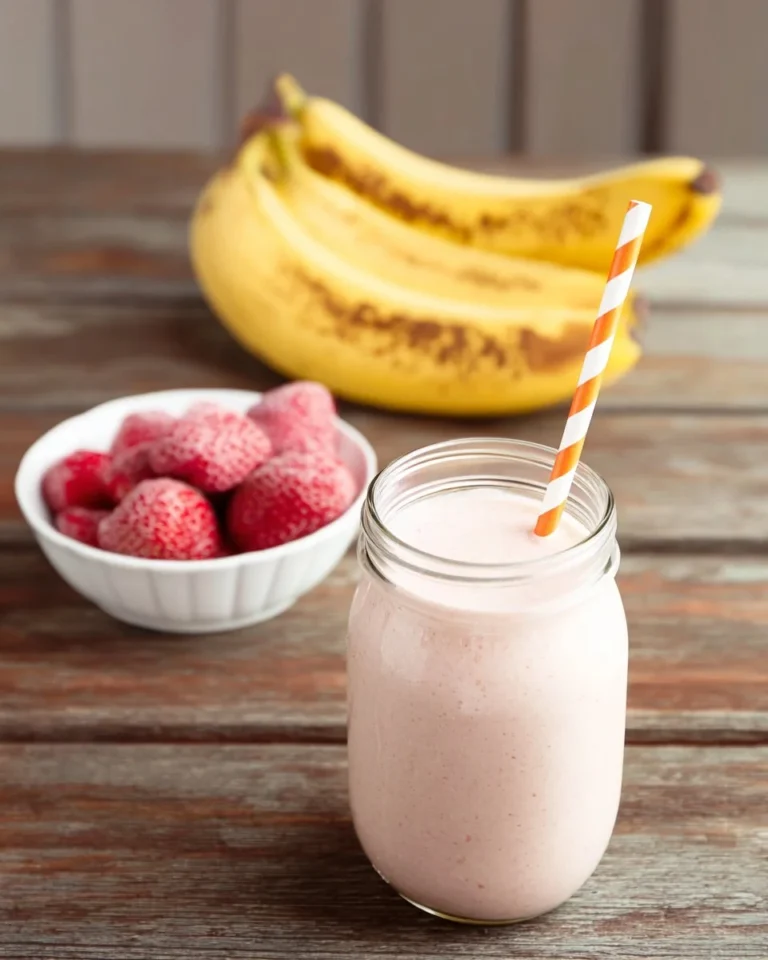 Creamy strawberry banana smoothie in a glass with fresh strawberries and bananas